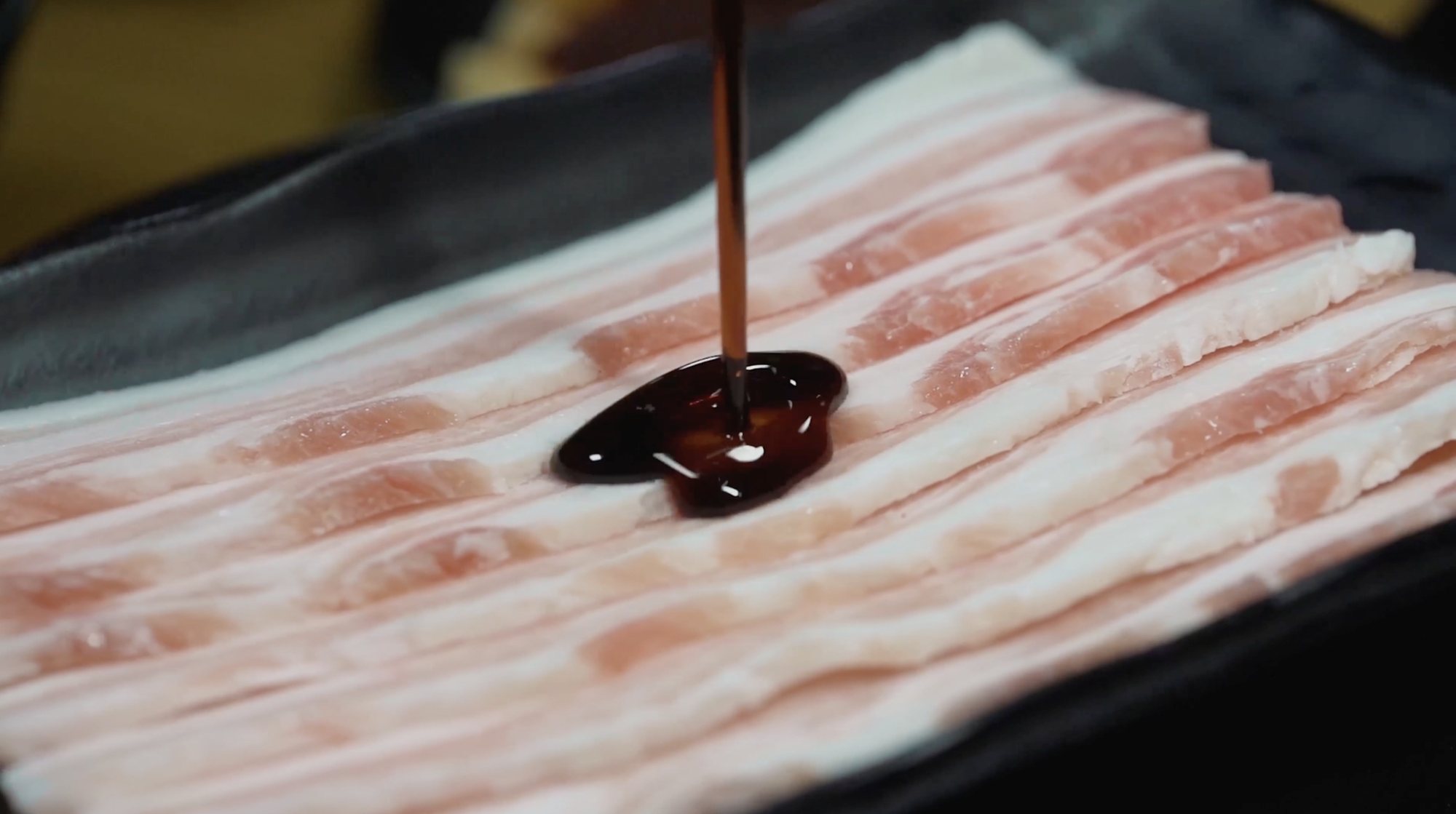 Sauce drizzled over sliced pork belly