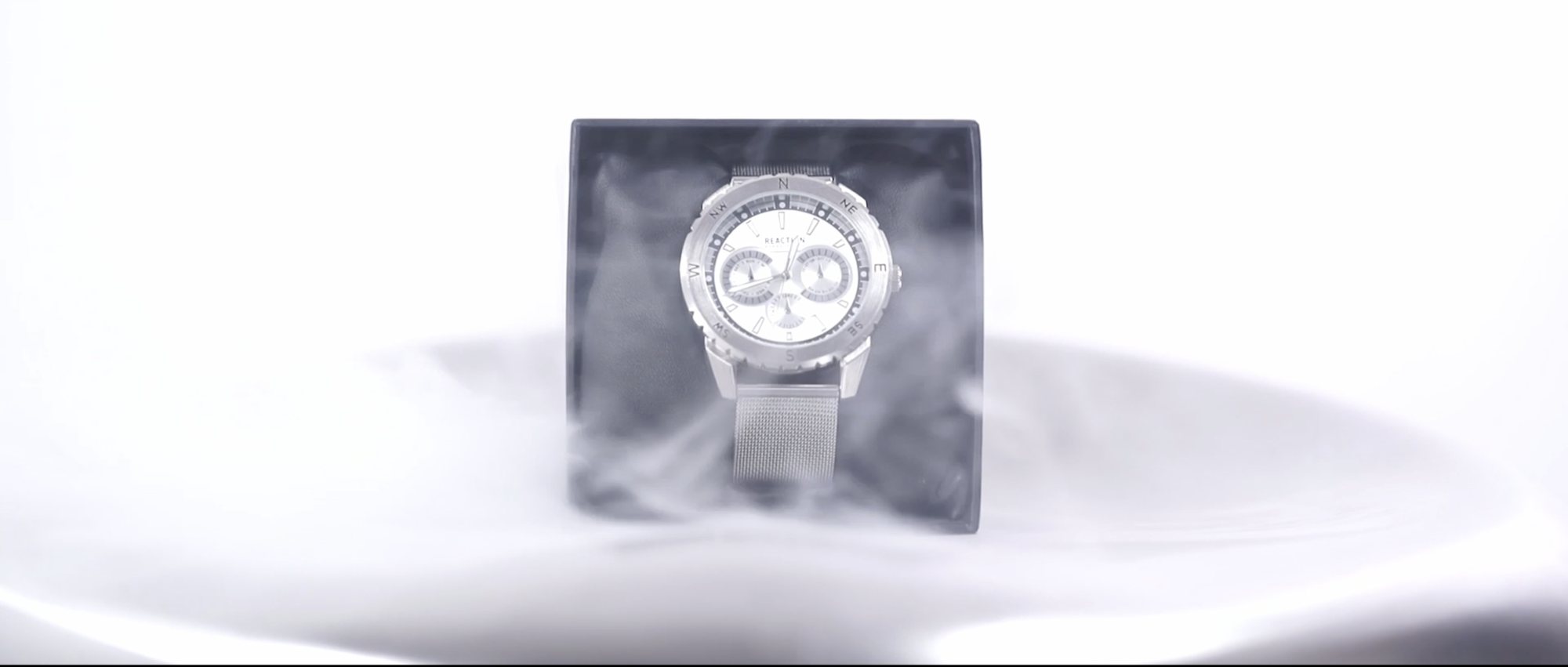 Watch on a white plinth wrapped in low fog