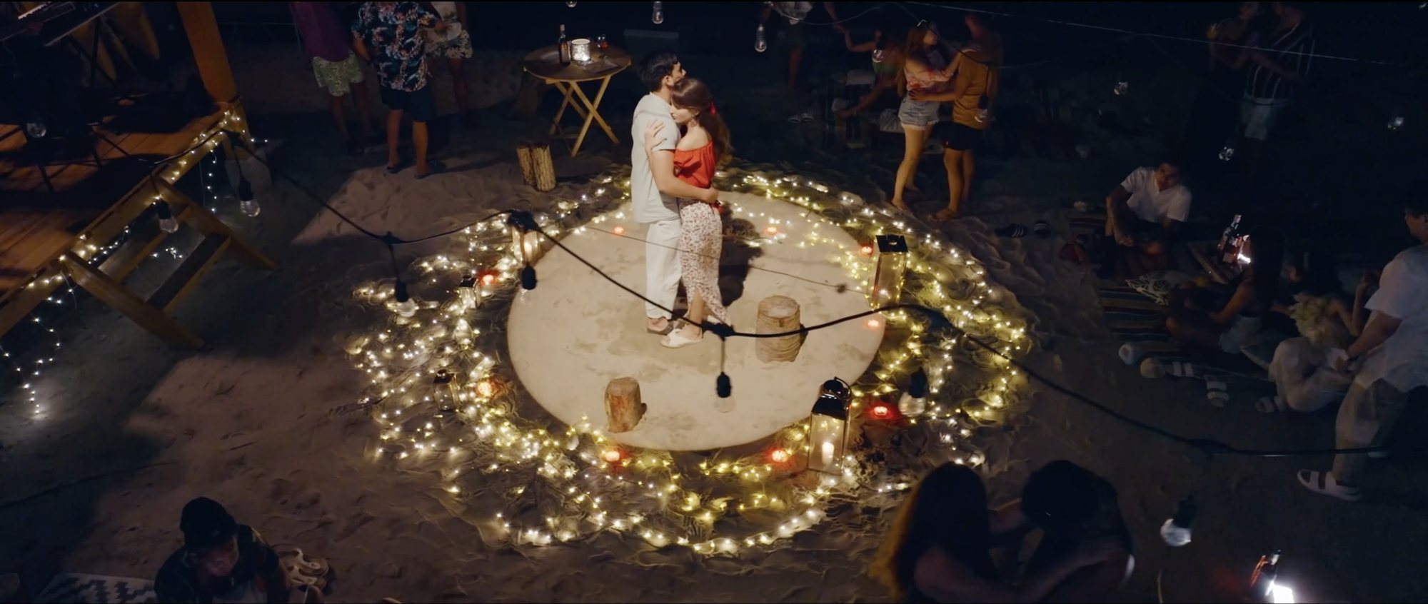 Couple in a ring of string lights at night
